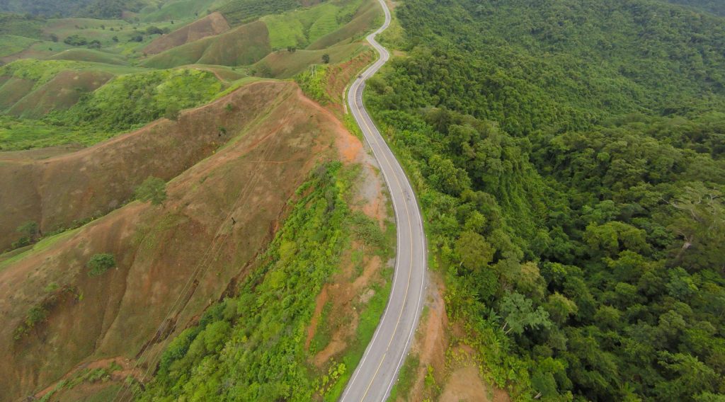 A winding road through lush green mountains in Tambon Nong Chaeng, Thailand.
