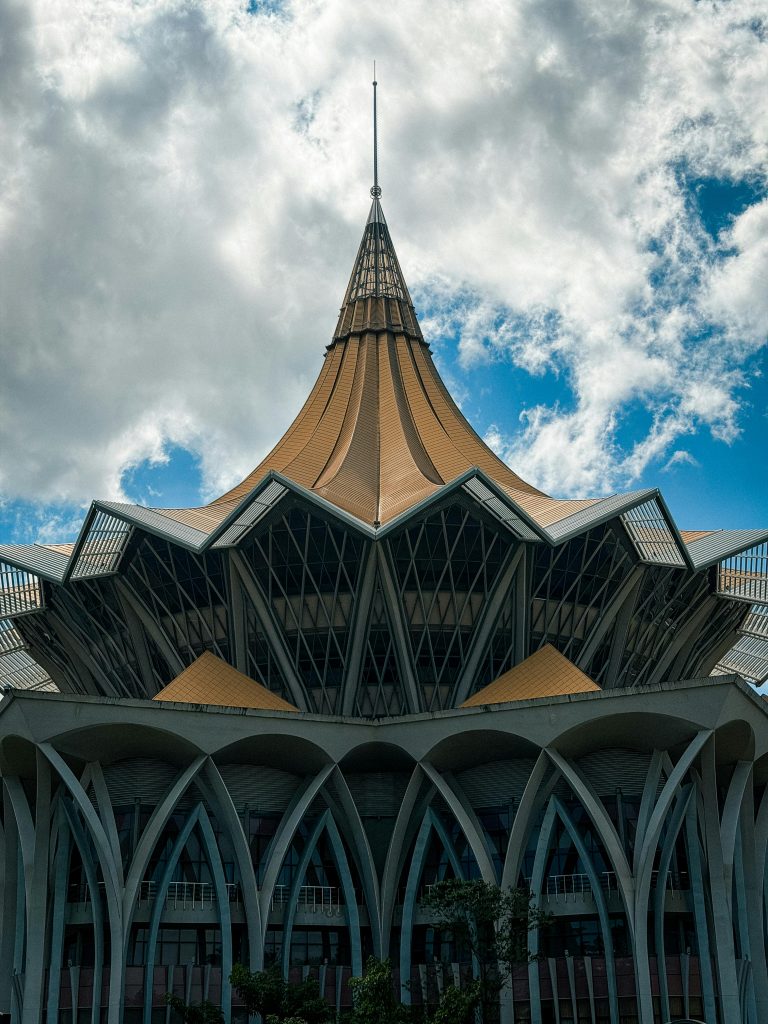 Striking architecture of Dewan Undangan Negeri Sarawak against a bright sky in Kuching, Malaysia.