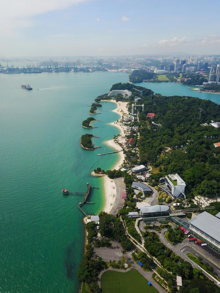 Explore the stunning aerial view of Singapore's Sentosa Island with its white sandy beaches and lush greenery.