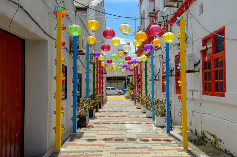 Vibrant lanterns hang in a decorated alley in Penang, Malaysia, showcasing cultural charm.