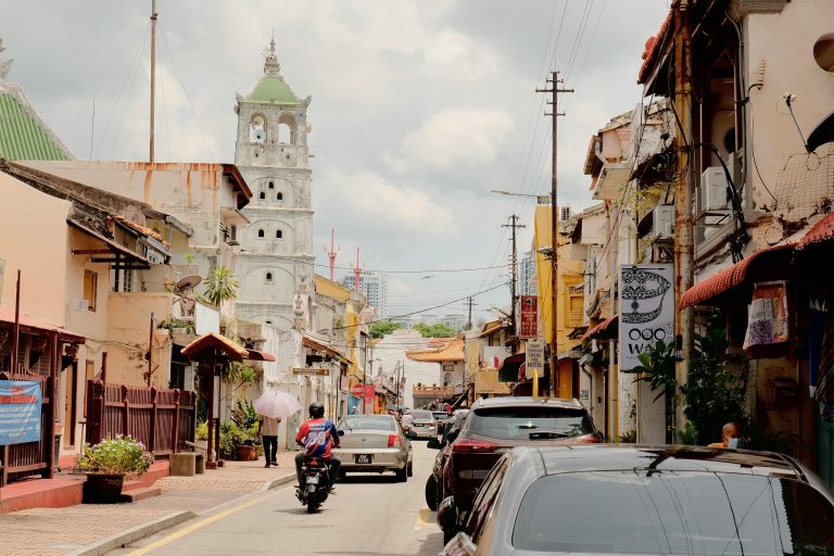 Charming street view of Malacca featuring the iconic Kampong Kling Mosque and local architecture.